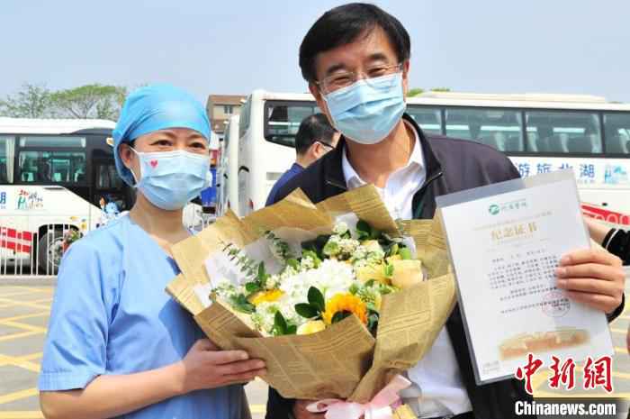 武汉同济医院医务人员给王辰院士送鲜花 王康荣 摄 中日友好医院援鄂医疗队返程 被授“同济医院职工”